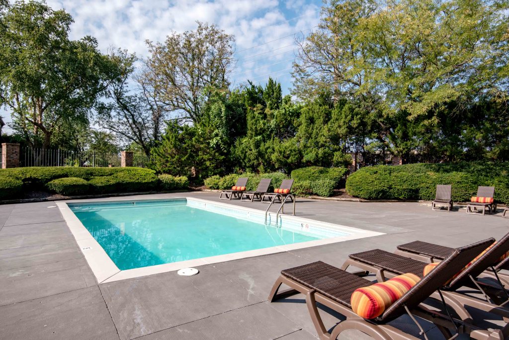 A shared amenity swimming pool surrounded by lush nature at Corinth Communities