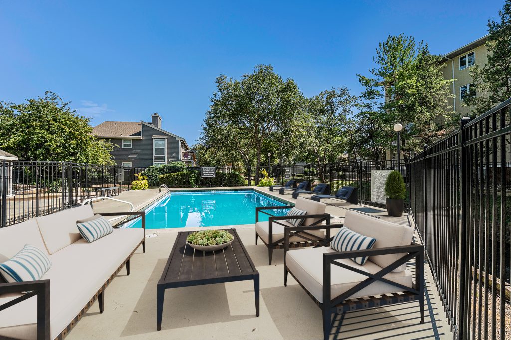 A luxurious pool deck with a lounging area in the middle of Corinth Communities.